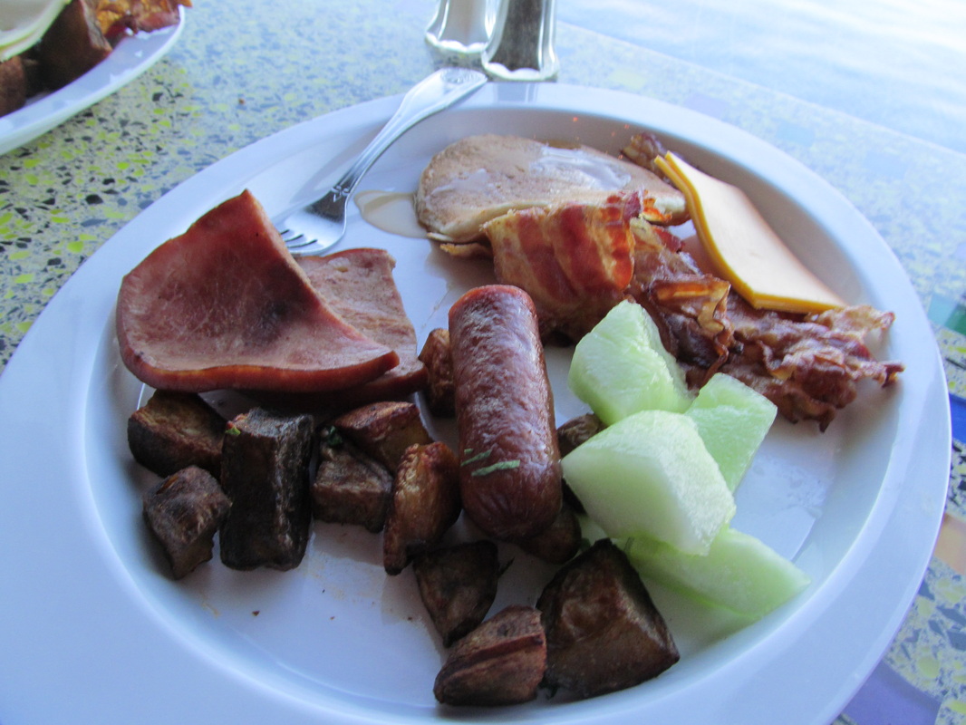 Hams, Sausage, Bacon, and Fruit on Breakfast Plate