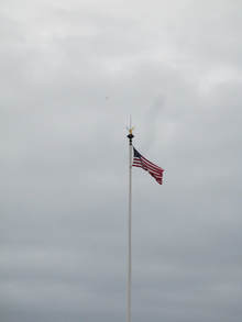 One of two American flags flying nearby the statue