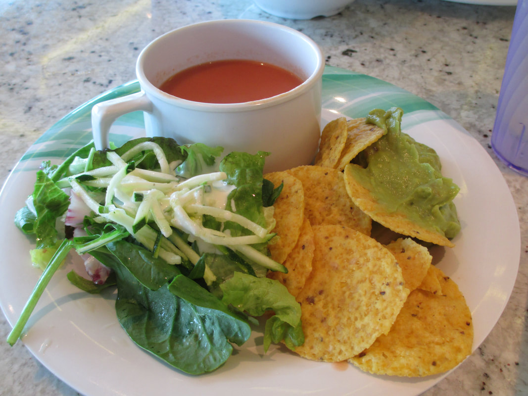 Soup and salad with delicious guacamole and chips for lunch